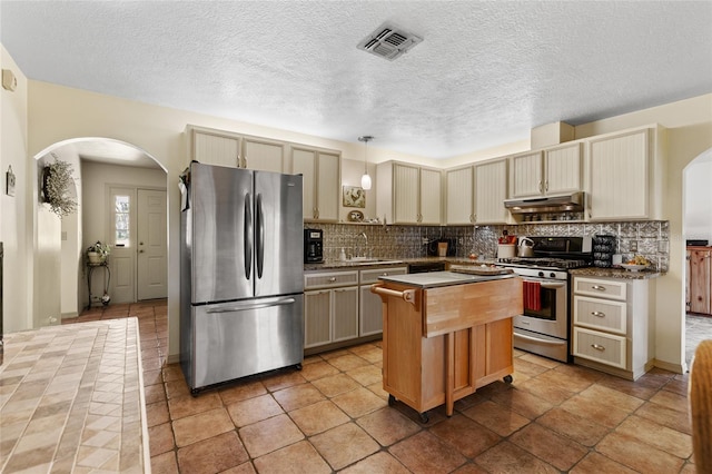 7450 SE State Road 121, Morriston, FL 32668 - kitchen featuring stainless steel appliances, arched walkways, a sink, under cabinet range hood, and tasteful backsplash