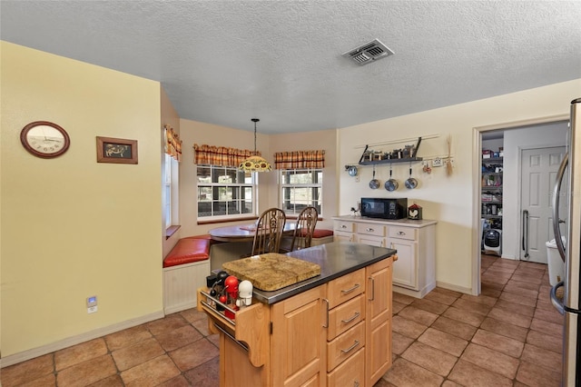 7450 SE State Road 121, Morriston, FL 32668 - kitchen featuring black microwave, a kitchen island, freestanding refrigerator, baseboards, and dark countertops