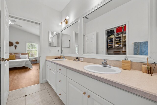 bathroom featuring double vanity, connected bathroom, tile patterned floors, a ceiling fan, and a spacious closet