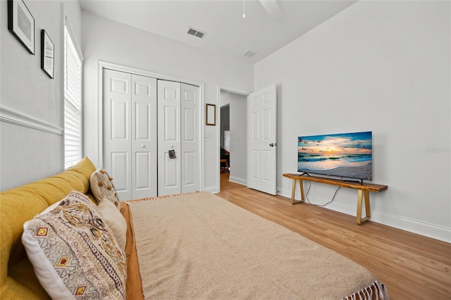 bedroom featuring wood finished floors, a closet, baseboards, and a ceiling fan
