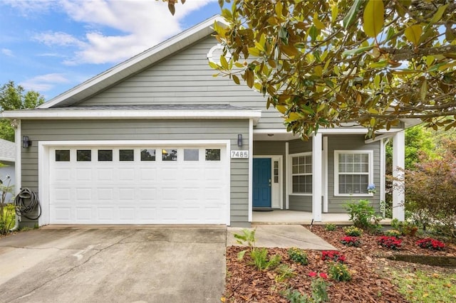 view of front of property featuring covered porch, driveway, and a garage