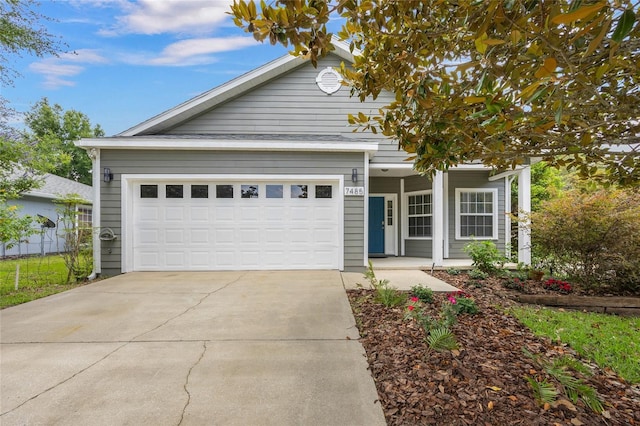 7485 NW 121st Ave, Alachua, FL 32615 - view of front of house with a porch, concrete driveway, and a garage