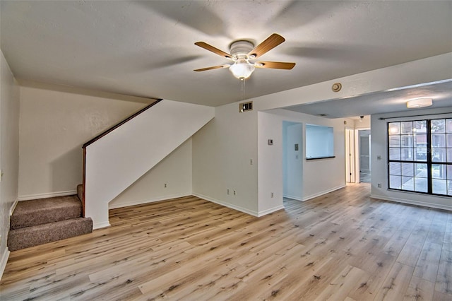additional living space with stairs, baseboards, light wood-type flooring, and a ceiling fan