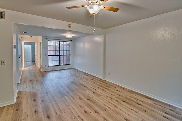 spare room featuring light wood-style floors, baseboards, and a ceiling fan