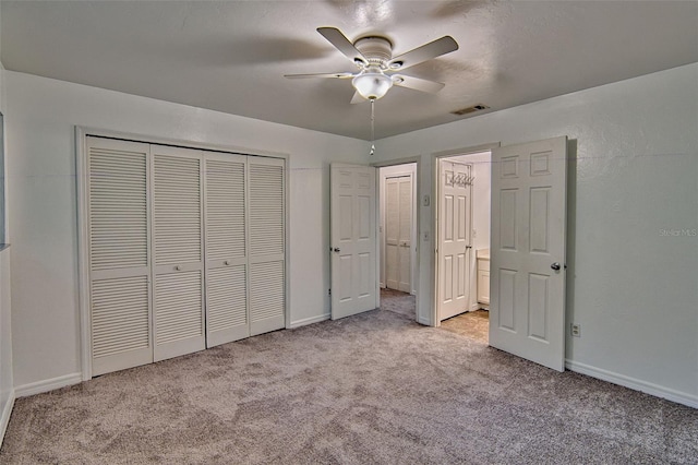 unfurnished bedroom with light colored carpet, a closet, baseboards, and a ceiling fan