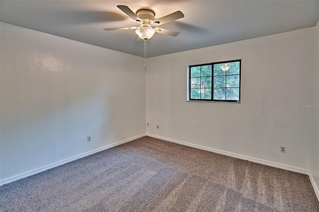 carpeted empty room featuring ceiling fan and baseboards