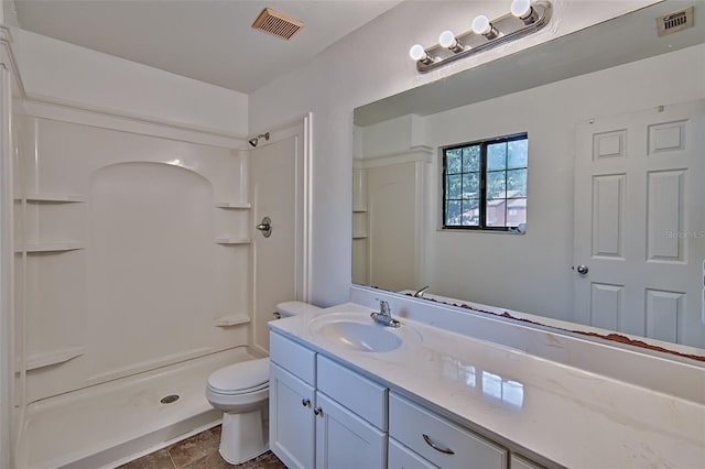 full bathroom featuring toilet, a stall shower, and vanity
