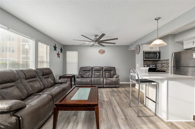 2601 SW Archer Rd Unit G 128, Gainesville, FL 32608 - living room featuring ceiling fan, light wood finished floors, and a textured ceiling