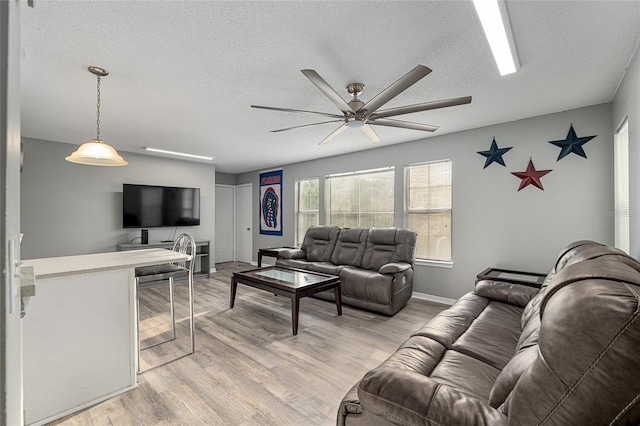 2601 SW Archer Rd Unit G 128, Gainesville, FL 32608 - living room featuring ceiling fan, a textured ceiling, light wood finished floors, and baseboards