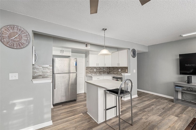 2601 SW Archer Rd Unit G 128, Gainesville, FL 32608 - kitchen with appliances with stainless steel finishes, light countertops, dark wood-style floors, tasteful backsplash, and white cabinets