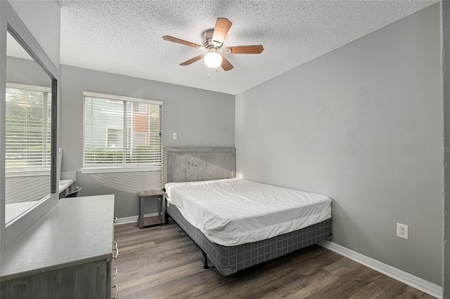 2601 SW Archer Rd Unit G 128, Gainesville, FL 32608 - bedroom featuring a textured ceiling, wood finished floors, baseboards, and ceiling fan