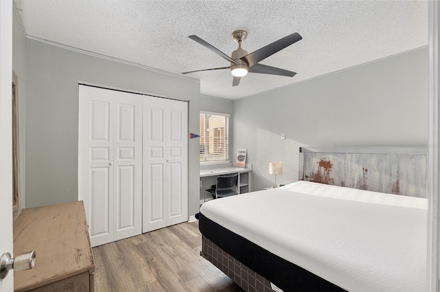 2601 SW Archer Rd Unit G 128, Gainesville, FL 32608 - bedroom with wood finished floors, a closet, a ceiling fan, and a textured ceiling