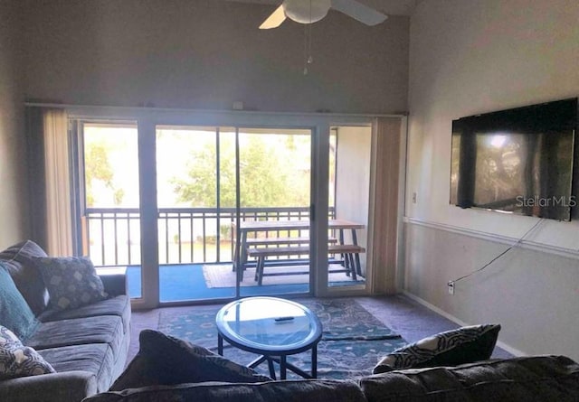 carpeted living room with a ceiling fan and baseboards