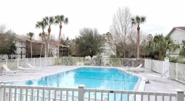 community pool featuring a patio and fence