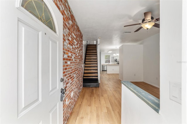 4415 SW 34th St Unit 503, Gainesville, FL 32608 - hall featuring brick wall, light wood-style flooring, stairs, and baseboards