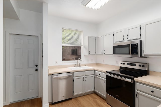 4415 SW 34th St Unit 503, Gainesville, FL 32608 - kitchen with stainless steel appliances, a sink, light wood finished floors, and light countertops