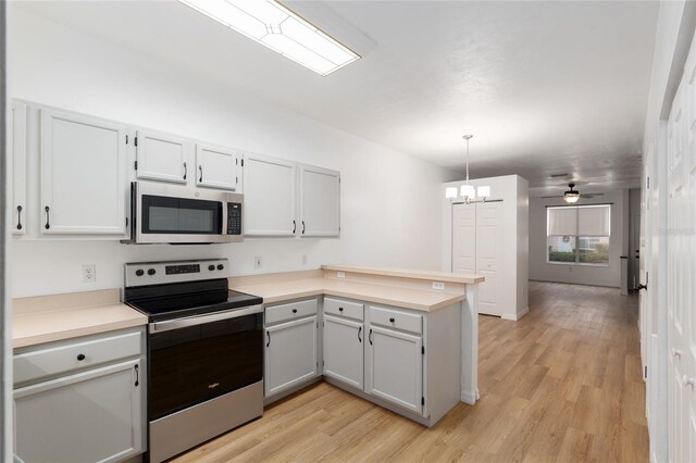 4415 SW 34th St Unit 503, Gainesville, FL 32608 - kitchen with stainless steel appliances, a peninsula, light wood finished floors, light countertops, and a chandelier