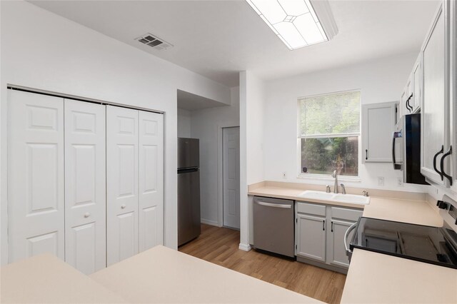 4415 SW 34th St Unit 503, Gainesville, FL 32608 - kitchen with appliances with stainless steel finishes, a sink, light wood-type flooring, and light countertops