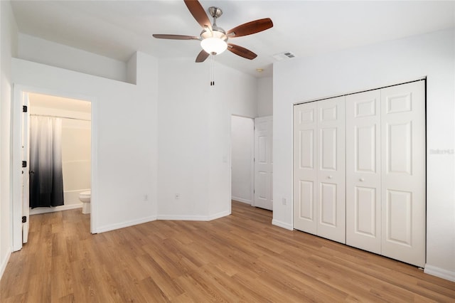 4415 SW 34th St Unit 503, Gainesville, FL 32608 - unfurnished bedroom with light wood finished floors, baseboards, a closet, a ceiling fan, and ensuite bath