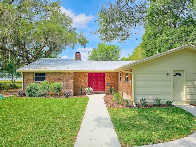 7972 State Rd Unit 100, Keystone Heights, FL 32656 - ranch-style house with brick siding, a front yard, a chimney, and metal roof
