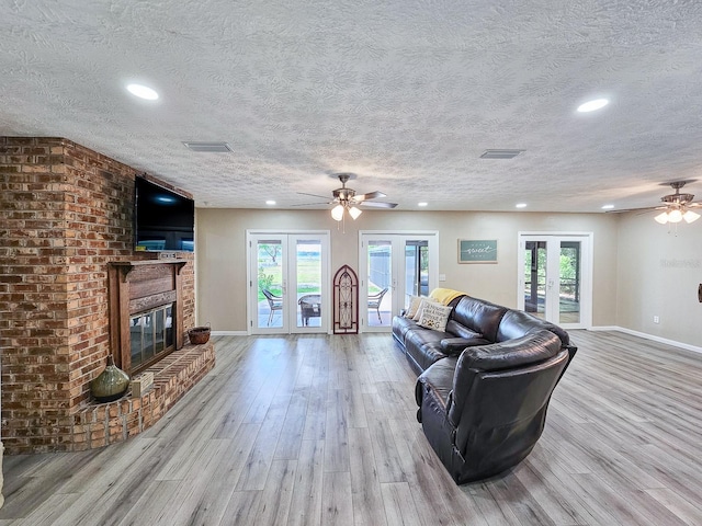 7972 State Rd Unit 100, Keystone Heights, FL 32656 - living room featuring ceiling fan, a textured ceiling, wood finished floors, baseboards, and a fireplace