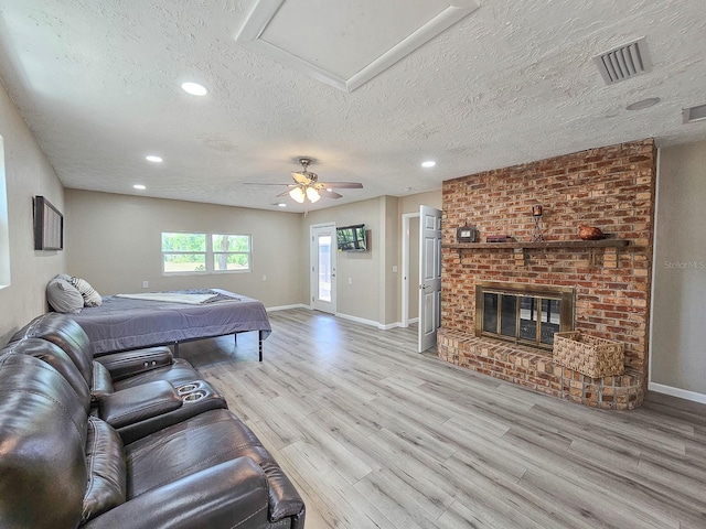 7972 State Rd Unit 100, Keystone Heights, FL 32656 - living room featuring a textured ceiling, wood finished floors, baseboards, recessed lighting, and a brick fireplace