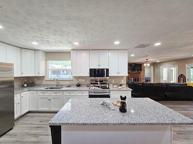 7972 State Rd Unit 100, Keystone Heights, FL 32656 - kitchen with stainless steel appliances, a sink, light wood-type flooring, white cabinets, and recessed lighting