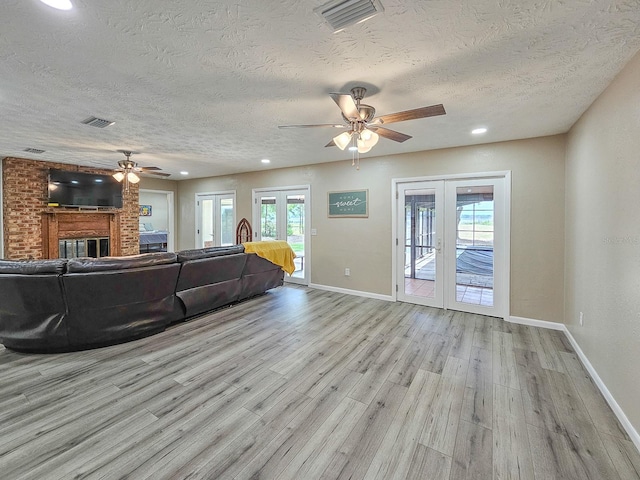 7972 State Rd Unit 100, Keystone Heights, FL 32656 - living room featuring a ceiling fan, a textured ceiling, french doors, light wood-type flooring, and baseboards