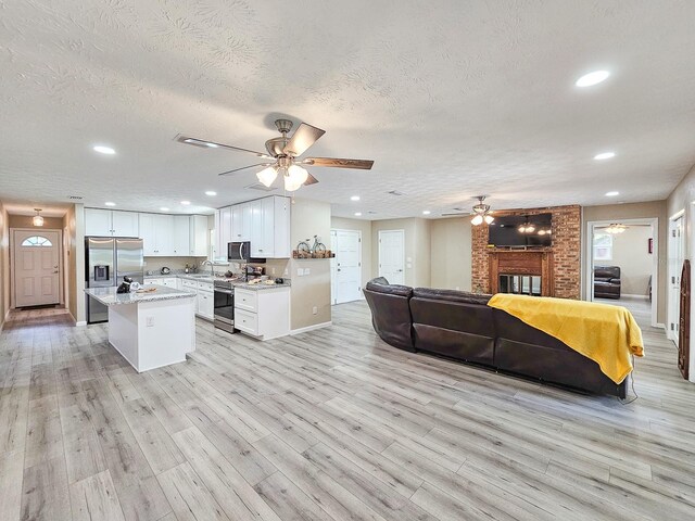 7972 State Rd Unit 100, Keystone Heights, FL 32656 - kitchen with a ceiling fan, open floor plan, a sink, appliances with stainless steel finishes, and white cabinetry