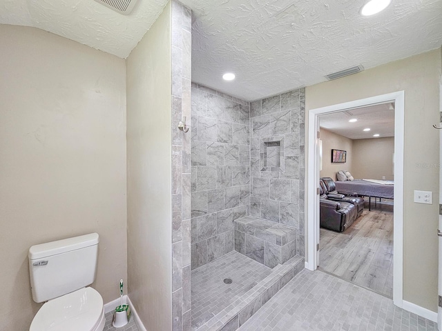 7972 State Rd Unit 100, Keystone Heights, FL 32656 - bathroom featuring recessed lighting, baseboards, tiled shower, toilet, and a textured ceiling