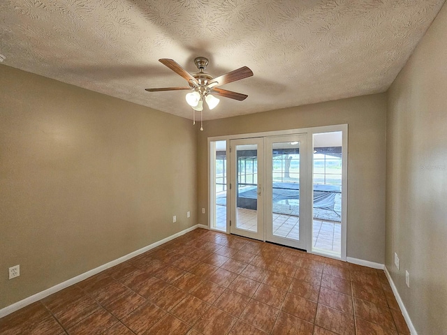 7972 State Rd Unit 100, Keystone Heights, FL 32656 - unfurnished room with baseboards, ceiling fan, dark tile patterned floors, and a textured ceiling