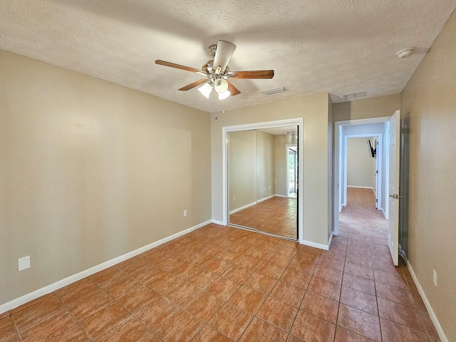7972 State Rd Unit 100, Keystone Heights, FL 32656 - unfurnished bedroom with tile patterned floors, a closet, baseboards, a ceiling fan, and a textured ceiling