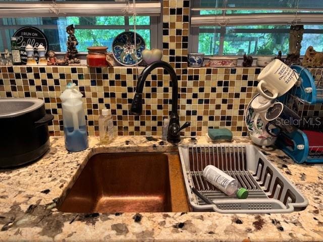 6410 SW 170th St, Archer, FL 32618 - kitchen view of a sink, tasteful backsplash, and light stone countertops