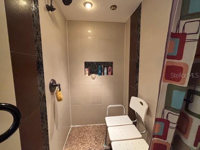 6410 SW 170th St, Archer, FL 32618 - bathroom featuring a shower and tile walls