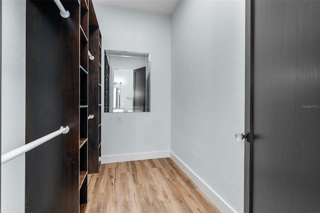 hallway with light wood-style flooring and baseboards