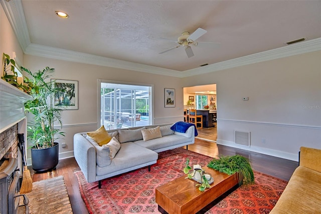 20250 NW 71st Ct, Micanopy, FL 32667 - living room featuring ceiling fan, wood finished floors, a fireplace, ornamental molding, and baseboards