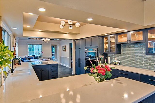 20250 NW 71st Ct, Micanopy, FL 32667 - kitchen with a sink, multiple ovens, decorative backsplash, a chandelier, and light countertops