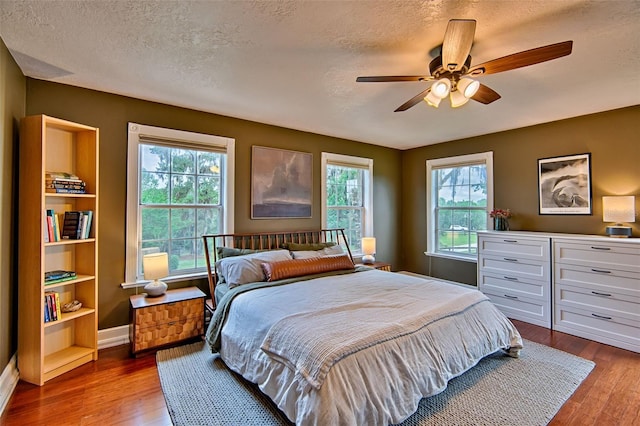 20250 NW 71st Ct, Micanopy, FL 32667 - bedroom with a textured ceiling, dark wood finished floors, multiple windows, and baseboards