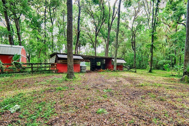 20250 NW 71st Ct, Micanopy, FL 32667 - view of yard featuring fence, an outbuilding, and a view of trees