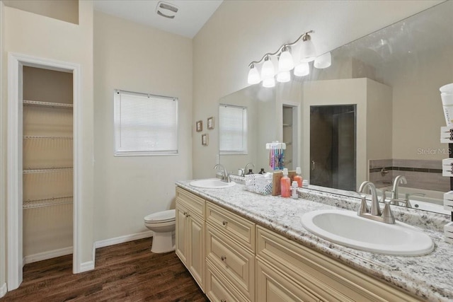 1180 Hough St, Bell, FL 32619 - bathroom with wood finished floors, toilet, a walk in closet, double vanity, and baseboards