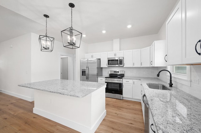 3645 Frederick Ave, Bell, FL 32619 - kitchen with stainless steel appliances, a sink, tasteful backsplash, a center island, and white cabinetry