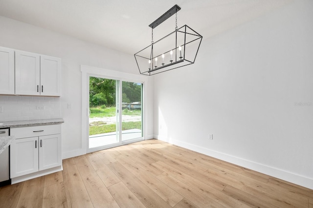 3645 Frederick Ave, Bell, FL 32619 - unfurnished dining area with a chandelier, light wood-style floors, and baseboards
