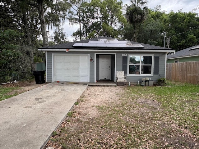 1312 NE 1st Ave, Gainesville, FL 32641 - view of front of home featuring roof mounted solar panels, fence, an attached garage, and driveway