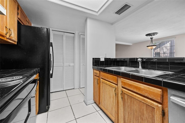 5841 SW 8th Pl, Gainesville, FL 32607 - kitchen featuring a sink, light tile patterned floors, black appliances, under cabinet range hood, and tile counters