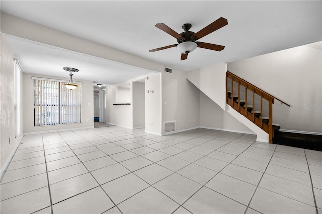 5841 SW 8th Pl, Gainesville, FL 32607 - unfurnished living room featuring ceiling fan, stairs, tile patterned flooring, and baseboards