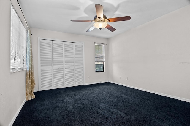 5841 SW 8th Pl, Gainesville, FL 32607 - unfurnished bedroom with dark colored carpet, a closet, baseboards, and a ceiling fan