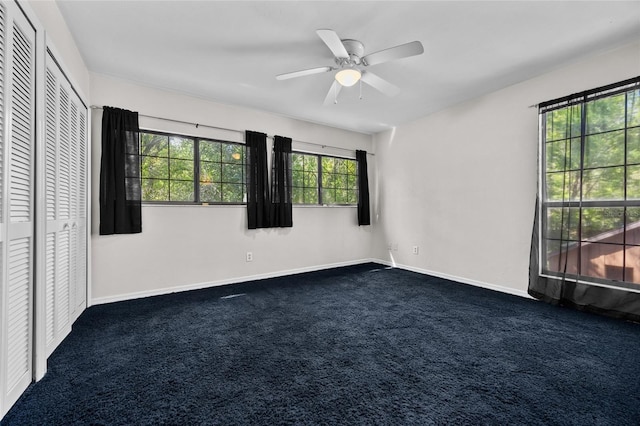 5841 SW 8th Pl, Gainesville, FL 32607 - unfurnished bedroom with dark colored carpet, baseboards, a ceiling fan, and a closet