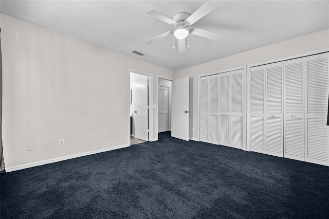 5841 SW 8th Pl, Gainesville, FL 32607 - unfurnished bedroom with multiple closets, dark colored carpet, baseboards, and ceiling fan