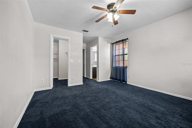 5841 SW 8th Pl, Gainesville, FL 32607 - unfurnished bedroom featuring baseboards, dark carpet, a walk in closet, and a ceiling fan