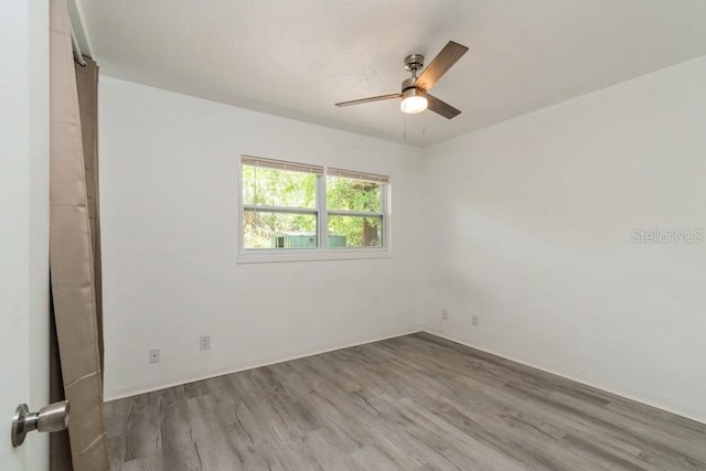 2911 NE 17th Ter, Gainesville, FL 32609 - empty room featuring wood finished floors, a ceiling fan, and baseboards